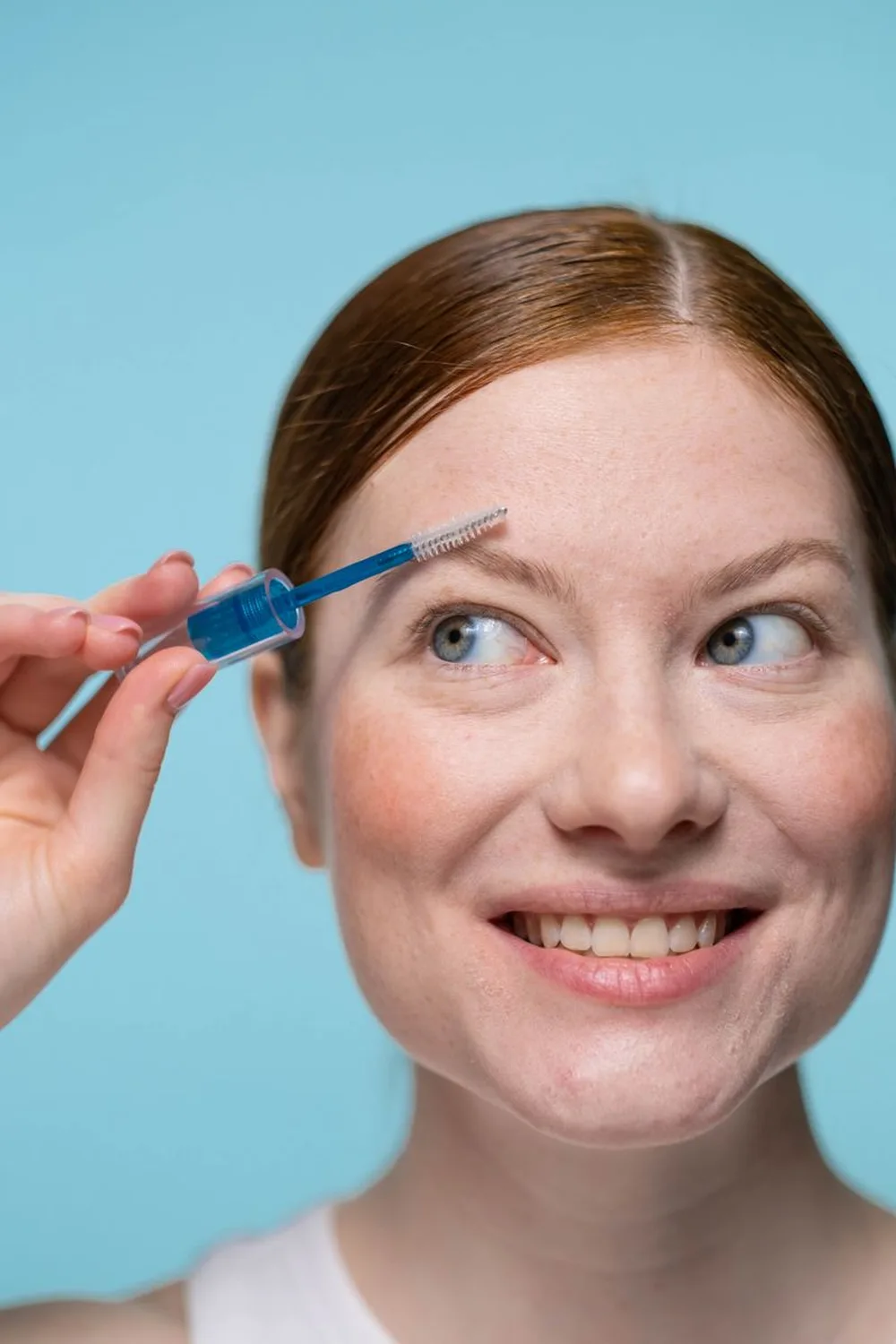 Applying a long lasting eyebrow gel with a spoolie wand