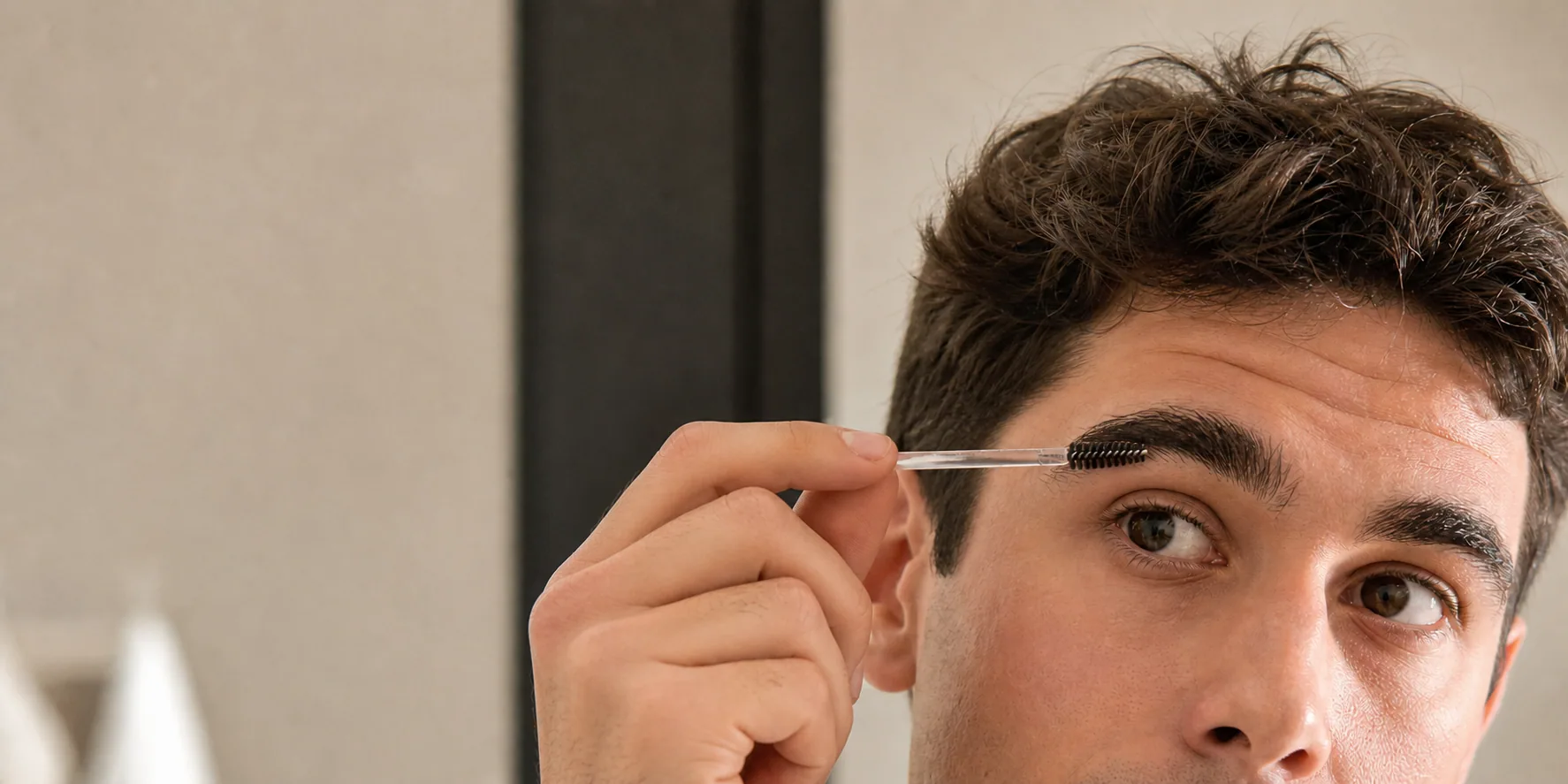 Best eyebrow gel for men being applied with a clear spoolie to thick natural brows